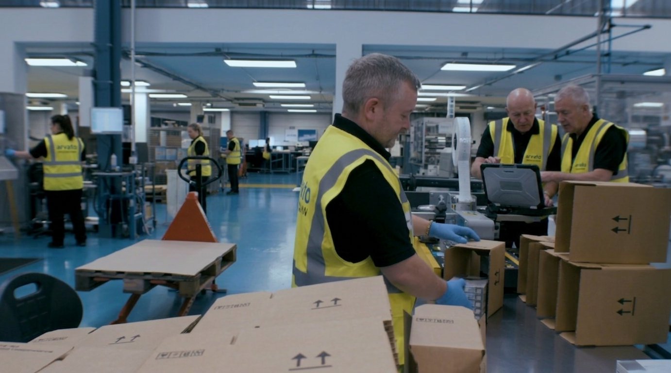 Arvato team packing finished product at a production station